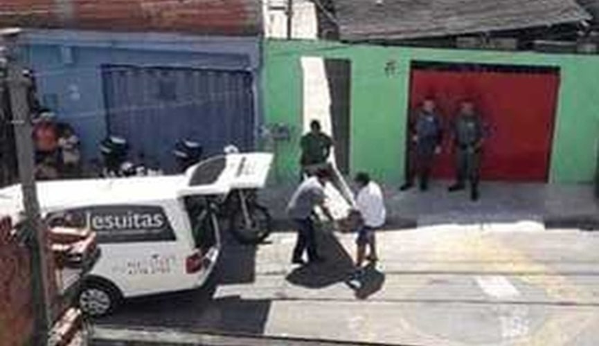 Corpo sendo carregado até carro funerário