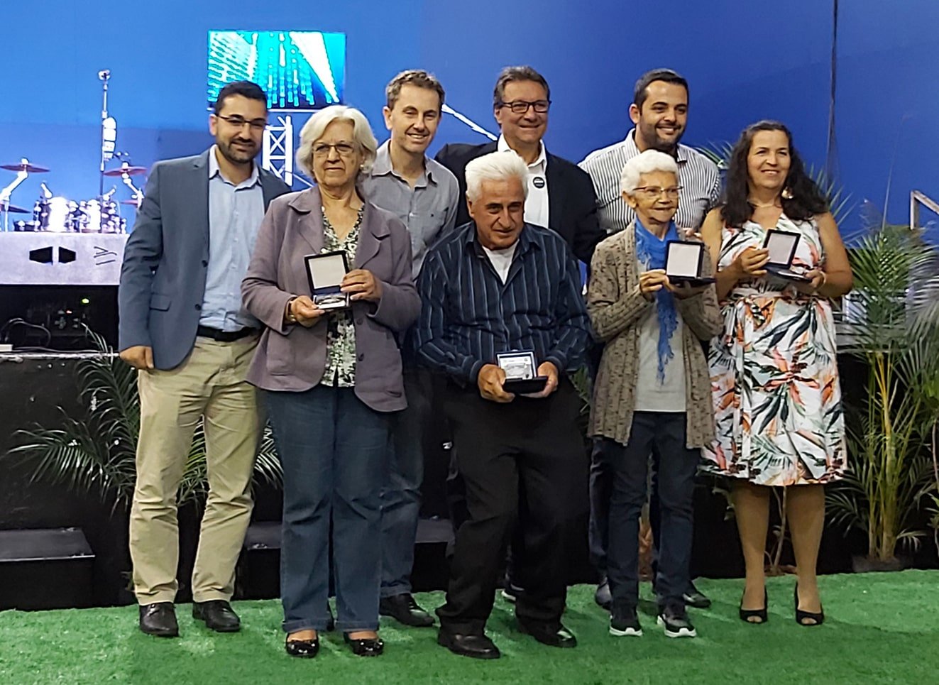 Grupo de pessoas segurando troféus
