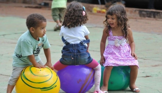Crianças em cima de bola plástica