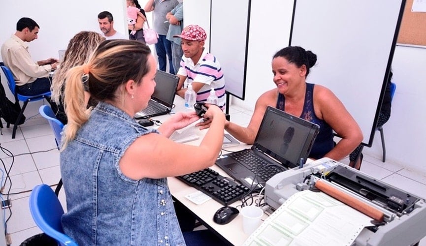 Mulher retirando a biometria de outra mulher no cartório eleitoral