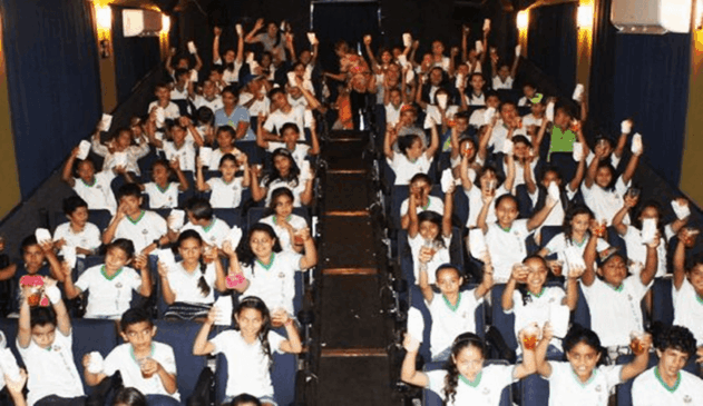 Foto de crianças dentro de cinema itinerante