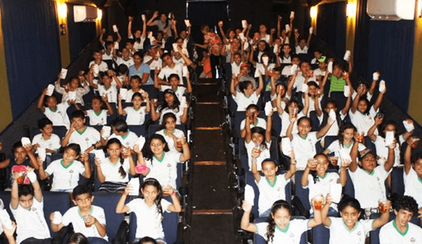 Foto de crianças dentro de cinema itinerante