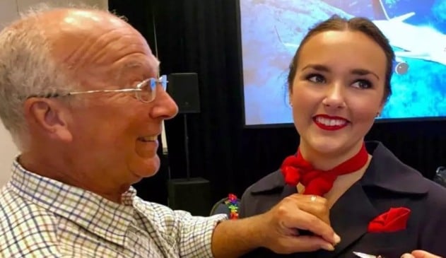 Senhor de idade arrumando broche em roupa de aeromoça