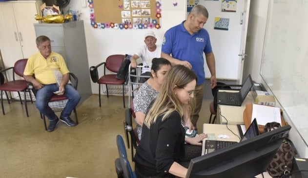 Mulher e homem atendendo idosos no Centro de Assistência