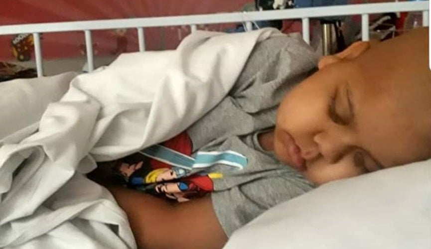 Criança parda e careca dormindo em quarto vermelho com temática de circo Criança parda e careca dormindo em quarto vermelho com temática de circo