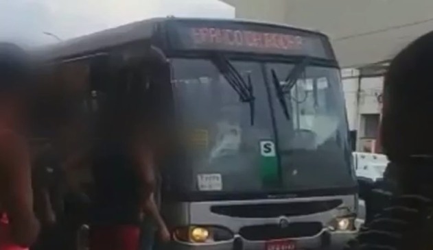 Foto de pessoas aglomerada ao lado de ônibus intermunicipal da rápido luxo