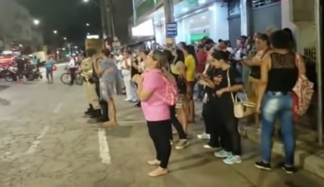 Multidão cantando na frente de prédio