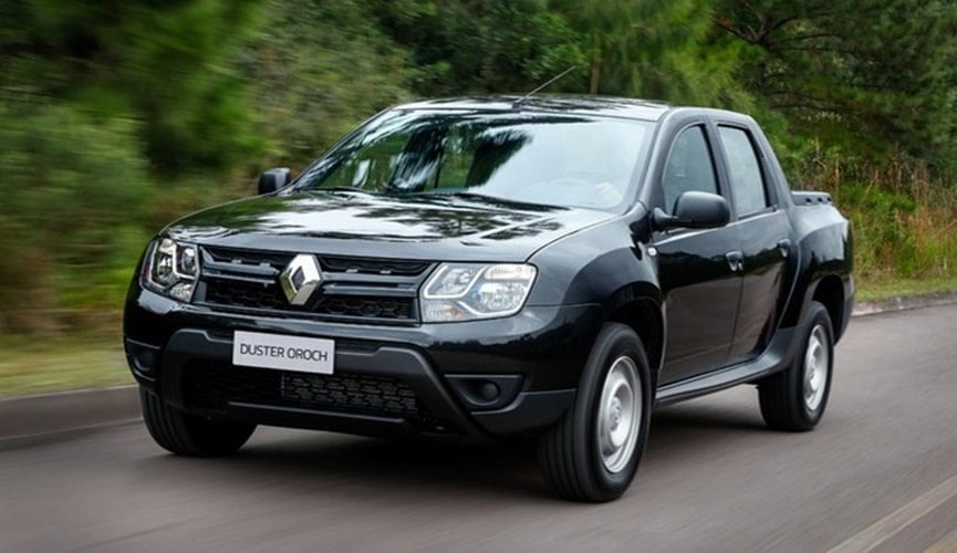 Picape preta em estrada com vegetação