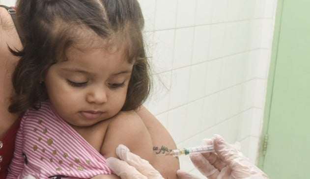 Criança tomando vacina de Sarampo