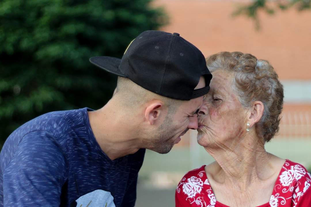 Senhora beijando o nariz de rapaz