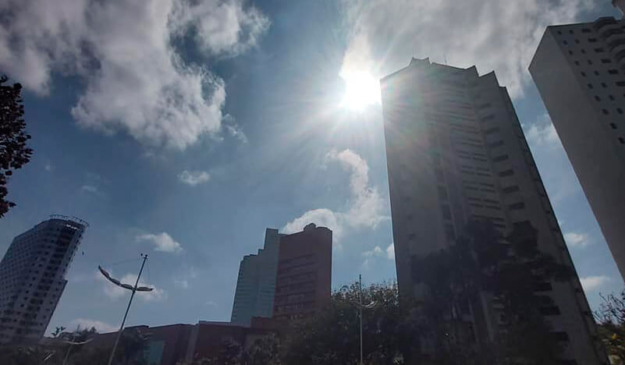 Nove de Julho de baixo para cima, com sol e nuvens