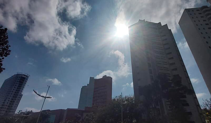 Nove de Julho de baixo para cima, com sol e nuvens