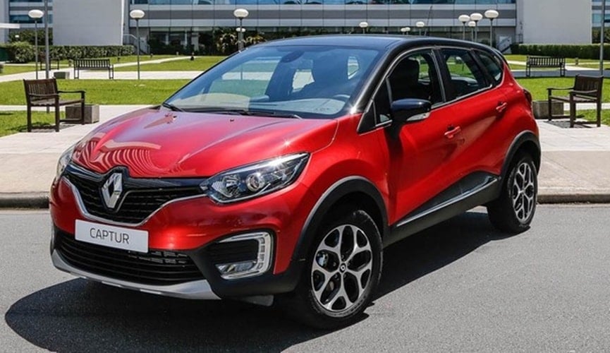 Carro Captur da Renault vermelho na frente de um prédio com gramado.