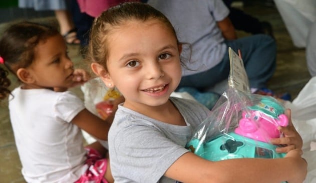 Menina com brinquedo nos braços