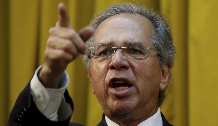 Foto de Paulo Guedes apontando dedo para câmera