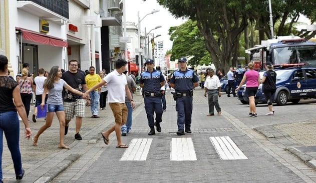 pessoas atravessando na faixa de pedestre no Centro de Jundiaí, com guardas municipais ao lado.