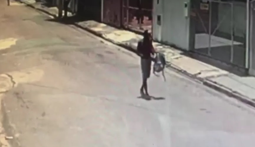 FOTO DE HOMEM COM MOCHILA ANDANDO EM AVENIDA