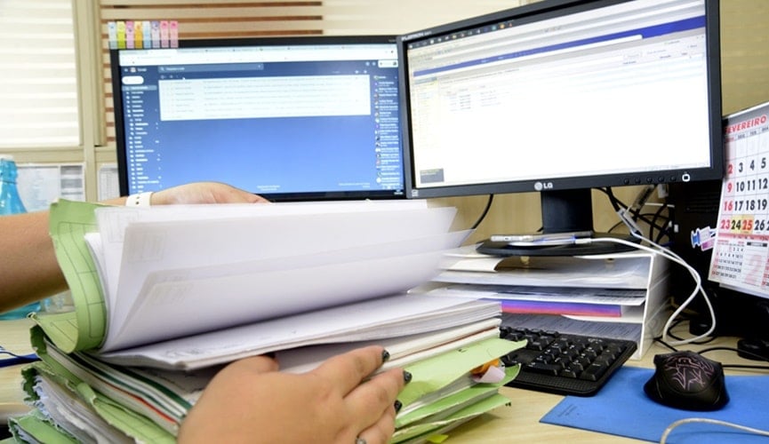 Computador com pasta de recibos em escritório