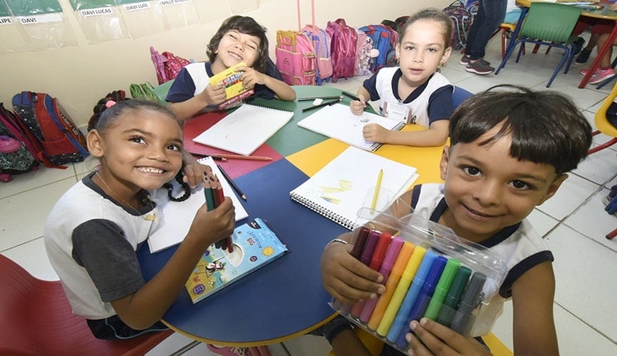 Foto de crianças com materiais escolares