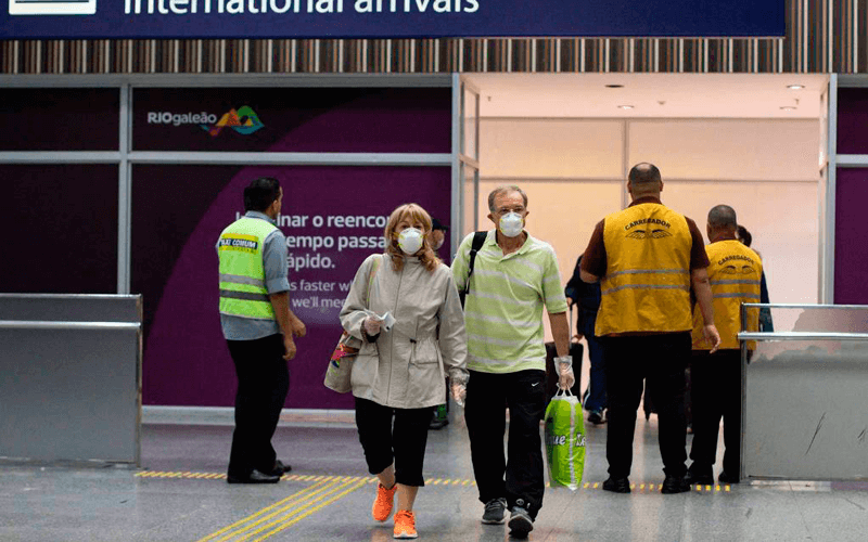 Passageiros chegam ao Galeão usando máscaras
