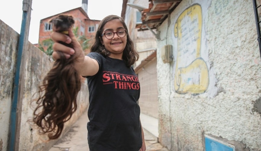 Menina de óculos segurando mecha de cabelo Menina de óculos segurando mecha de cabelo