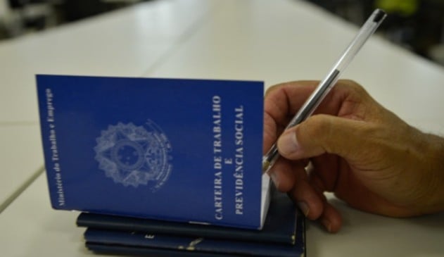 Pessoa assinando carteira de trabalho