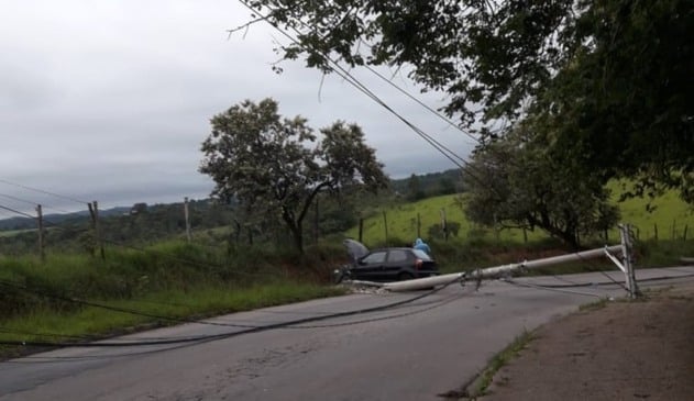 Carro batido em barranco, com postes derrubados ao lado
