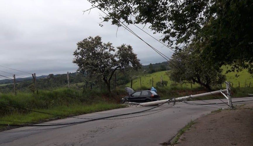 Carro batido em barranco, com postes derrubados ao lado