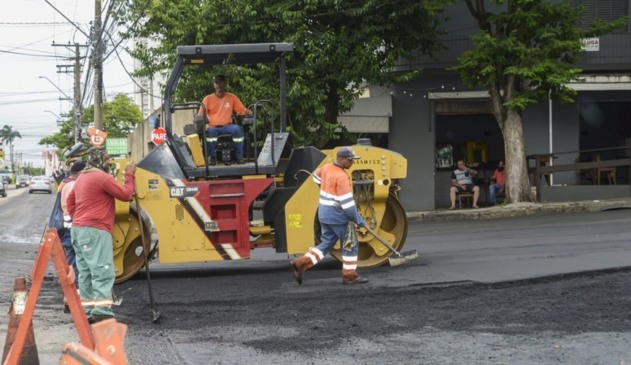 foto de máquina e homens trabalhando em recapeamento de via
