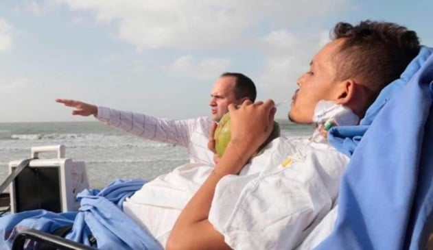 Homem deitado em maca na praia