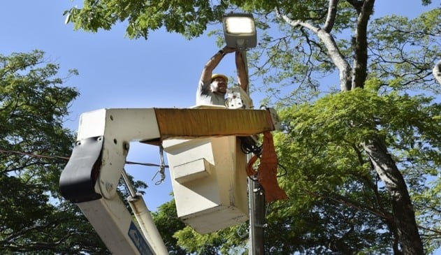 Eletricista instalando luminária de LED em poste
