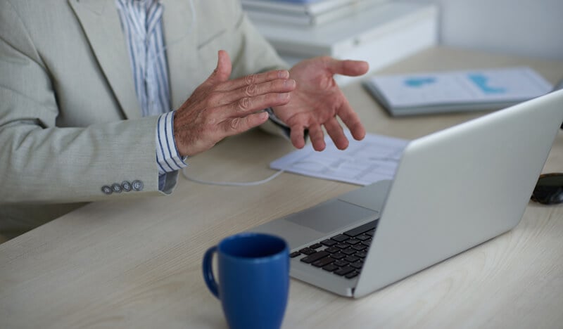 Homem de terno em vídeo chamada pelo notebook