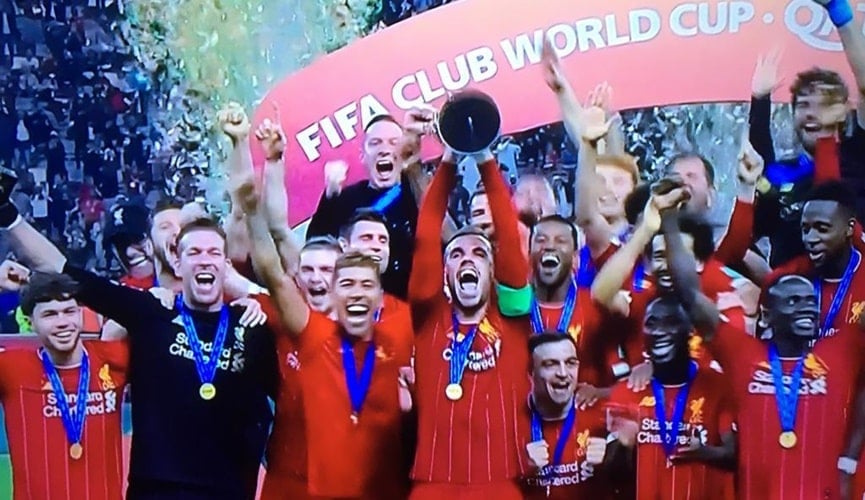 Atletas comemorando com troféu em mãos