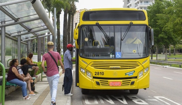 Pessoas entrando em ônibus amarelo
