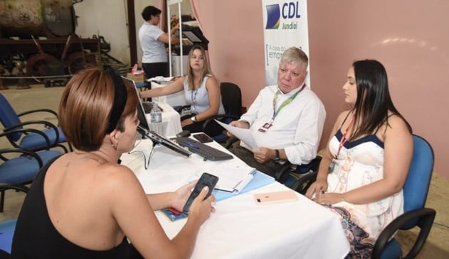Pessoas sentadas em mesa de negociação do mutirão de renegociação