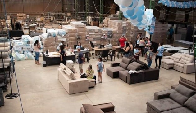 Foto de galpão com móveis e pessoas
