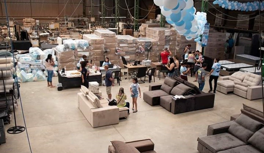Foto de galpão com móveis e pessoas