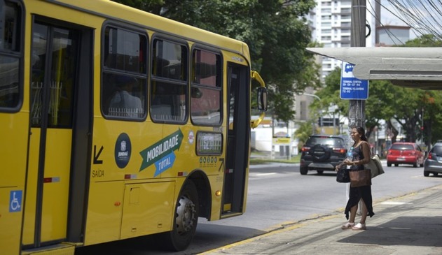 Mulher de vestido preto entrando em ônibus