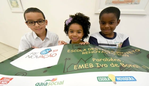 Crianças negras segurando panfleto de projeto educativo