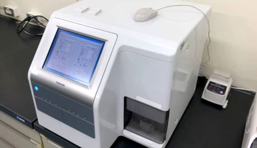 Equipamento branco, com tela digital, similar a uma impressora.