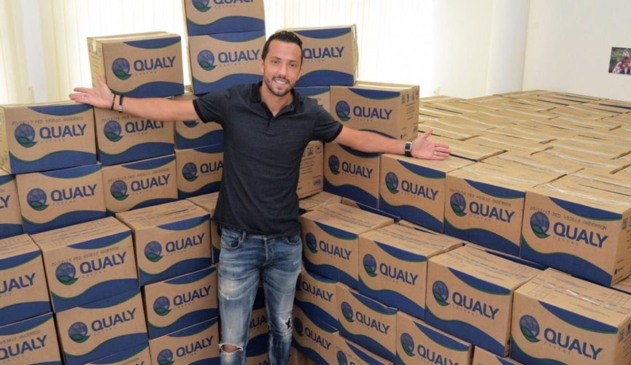 Foto do jogador ao lado das cestas básicas doadas