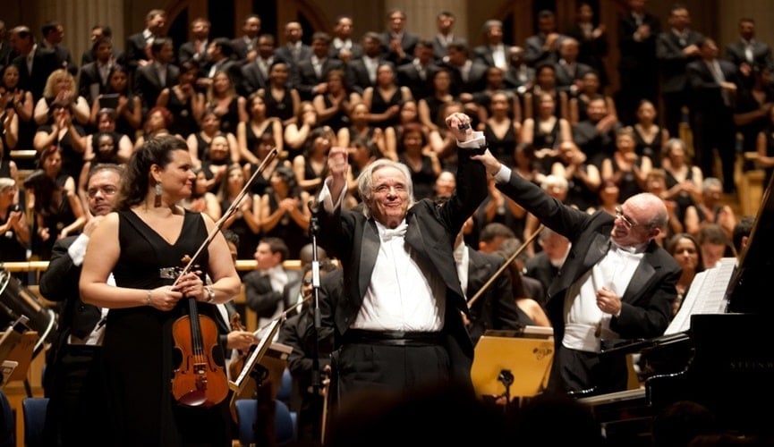 Foto de maestro regendo orquestra