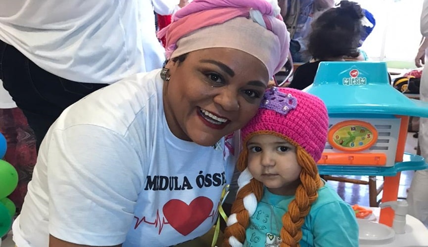 foto de mulher com turbante abraçando criança com peruca de princesa