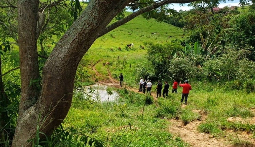 Foto de policiais em área de mata