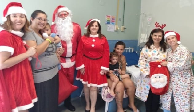 Papai e Mamãe Noel ao lado de pacientes internados no HU
