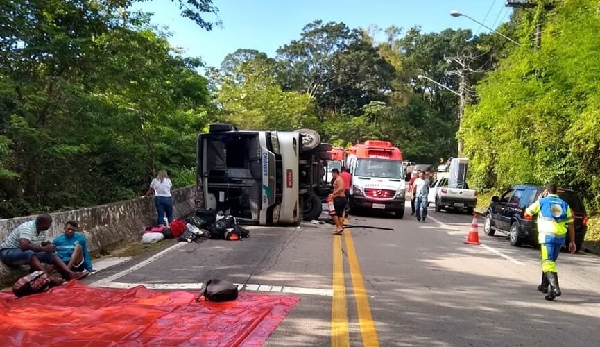 ônibus tombado em rodovia, ambulâncias e agentes prestando socorro aos passageiros