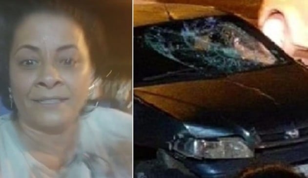 Selfie de mulher de meia idade parda, à direita; carro preto destruído, à esquerda