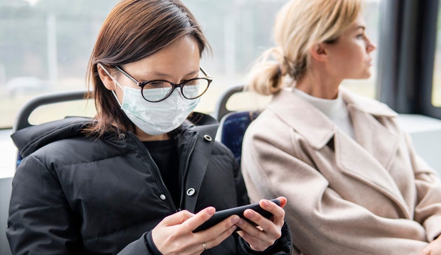 Foto de mulher de máscara ao lado de mulher sem máscara