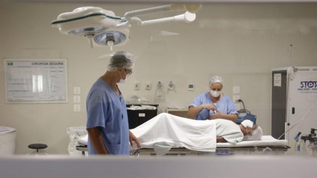 Médicos e paciente em sala de cirurgia