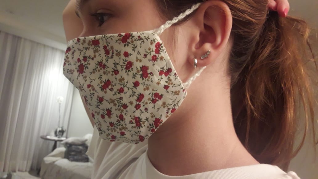 Foto de mulher com máscara florida de alça de crochê